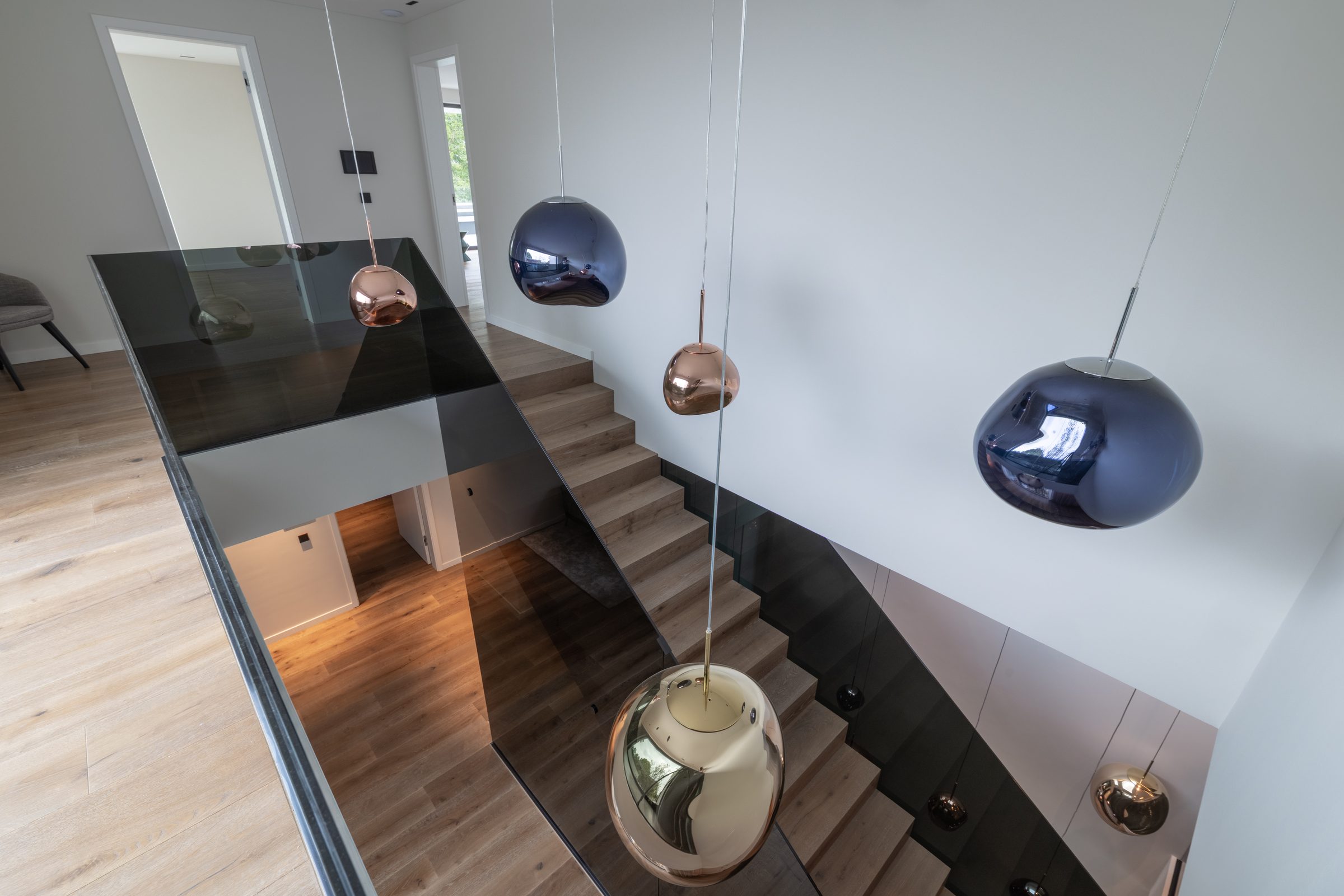 Treppenauge mit Designleuchten über mehreren Ebenen
